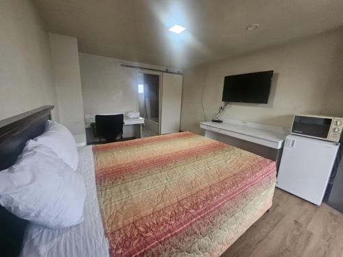 a hotel room with a bed and a television at Del Rancho Motel in Portland