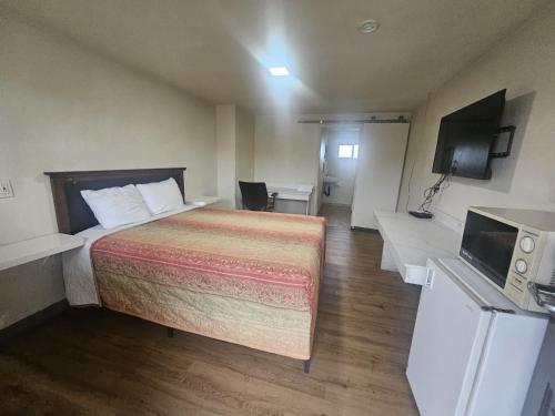 a hotel room with a bed and a television at Del Rancho Motel in Portland