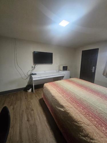 a hotel room with a bed and a flat screen tv at Del Rancho Motel in Portland