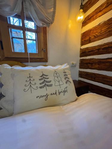 a bed with a pillow with a merry christmas written on it at Sadova Village-Casa Elena in Sadova