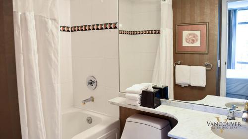 a bathroom with a tub and a toilet and a sink at Vancouver Extended Stay in Vancouver