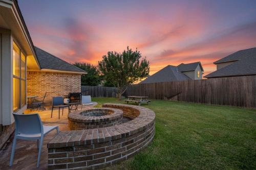 a backyard with a fire pit in the yard at 8min Texas A&M 1 King Beds firepit GriddleGrill in College Station