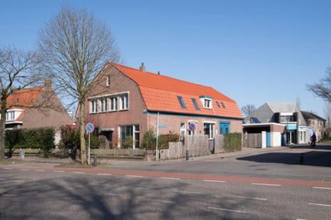 a house with an orange roof on the side of a street at Heerlijk dromen in 't Maantje in Waalwijk