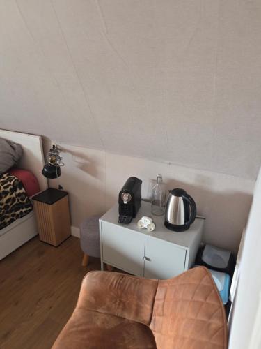 a room with a bed and a table with a tea kettle at Heerlijk dromen in 't Maantje in Waalwijk