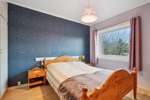 a bedroom with a wooden bed and a blue wall at Alam,s Villa in Kabelvåg