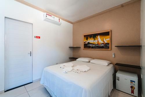 a bedroom with a bed with towels on it at Pousada La Belle in Maragogi