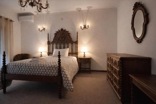 a bedroom with a bed and a dresser and a mirror at Moradia santa comba in Santa Comba Dão