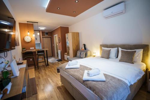 a bedroom with a large bed with towels on it at Studio DORA SS in Stari Banovci