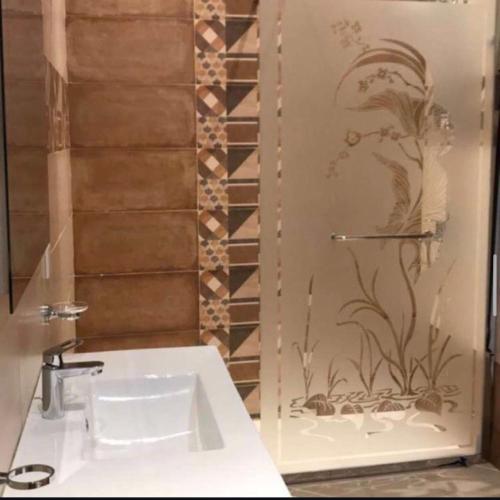a bathroom with a white sink and a wall at درة العروس ريفيرا in Durat Alarous