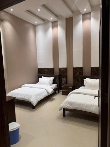 two beds in a room with white sheets at درة العروس ريفيرا in Durat Alarous