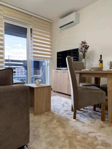 a living room with a table and a dining room at Apartman Kitanović 1 Vrnjačka Banja in Ruđinci