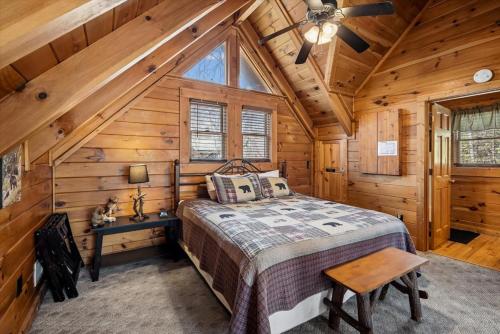 a bedroom with a bed in a log cabin at Beary Cozy Cabin by Venture Smoky Mountains in Sevierville