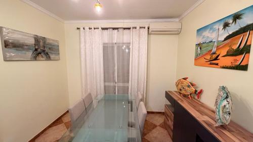 uma sala de estar com uma mesa de vidro e uma janela em Ria Studios em Olhão