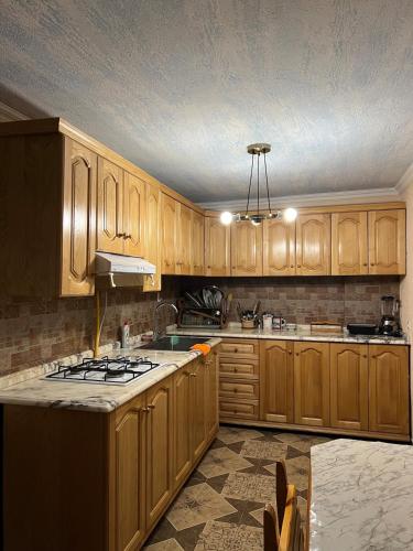 a kitchen with wooden cabinets and a stove top at Fireside Fiesta Haven in Maglaki