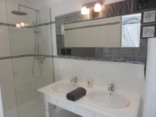a bathroom with two sinks and a glass shower at Mas les vieux chênes in Lambesc