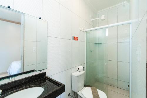 a bathroom with a toilet and a sink and a mirror at Pousada La Belle in Maragogi