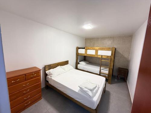 a bedroom with two bunk beds and a dresser at Pool house, garden, grill in Ica