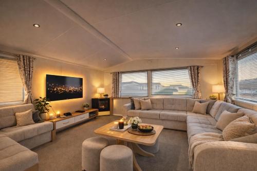 a large living room with a couch and a table at Cozy Family Caravan at Haven Kent Coast in Allhallows
