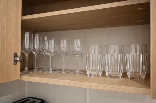 a row of wine glasses sitting on a shelf at Cozy Family Caravan at Haven Kent Coast in Allhallows