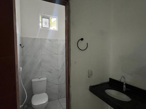 a bathroom with a toilet and a sink at Residencial Lourenço - Vila Preá in Cruz