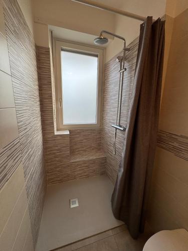 a bathroom with a shower with a window and a shower curtain at Great Sweet Home in Strambino