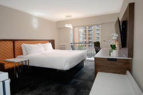 a hotel room with a bed and a balcony at The Vic, an Ascend Collection Hotel in Victoria