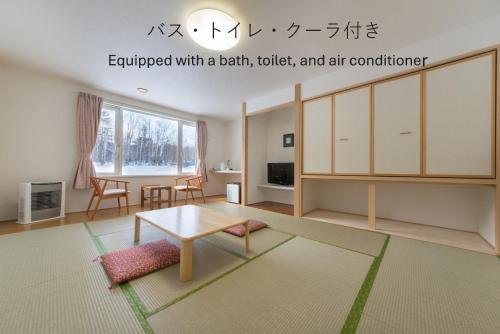 a living room with a table and a table at Shiretoko Village in Shari
