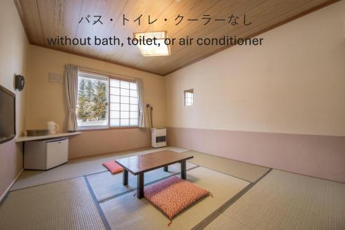 a room with a table in the middle of a room at Shiretoko Village in Shari