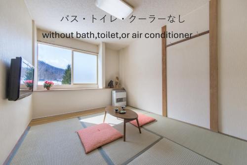 a living room with a table and a window at Shiretoko Village in Shari