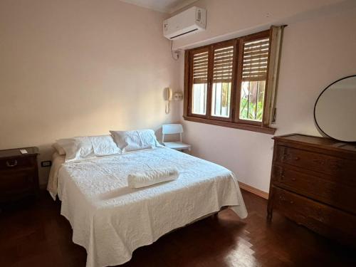 a white bed in a bedroom with a window at Casa Morotï - Casa de dos habitaciones en la Costanera de Corrientes in Corrientes