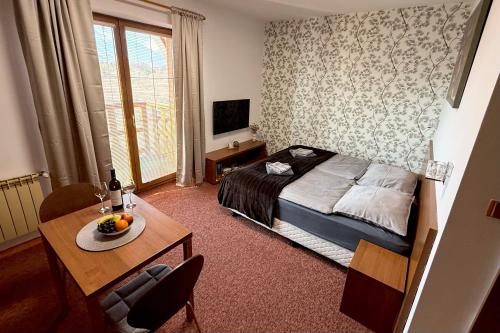 a hotel room with a bed and a table with a table at Apartmán Mountain View - Tatragolf C in Veľká Lomnica