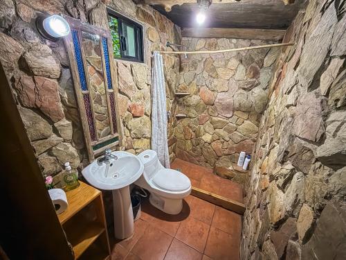 a stone bathroom with a sink and a toilet at Hotel del Bosque in Guatemala