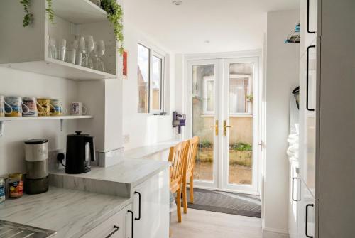 a kitchen with white cabinets and a counter top at Central Gosport Group Townhouse with Dedicated Workspace, Sleeps 9 in Brockhurst