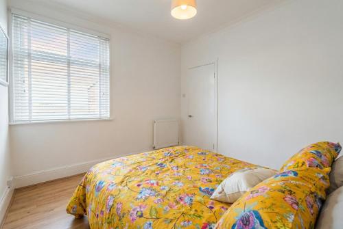 a bedroom with a bed with a yellow blanket at Central Gosport Group Townhouse with Dedicated Workspace, Sleeps 9 in Brockhurst