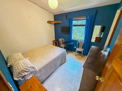 a bedroom with a bed and a blue wall at Hotel del Bosque in Guatemala