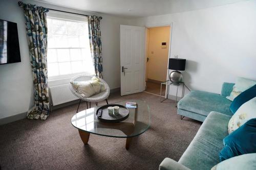 a living room with a couch and a table at Franks- 2nd Floor Apt-2 Bath-Cowes Centre-Sleeps 4 in Cowes