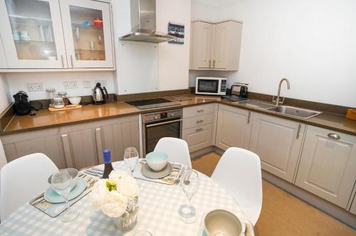 a kitchen with a table and chairs in a kitchen at Paskins - Cowes in Cowes