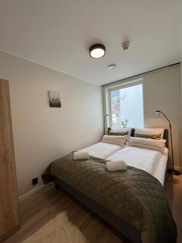 a bedroom with a large bed with a window at Affordable Luxury Apt - Hotel Vibe - Heart of Voss in Vossevangen