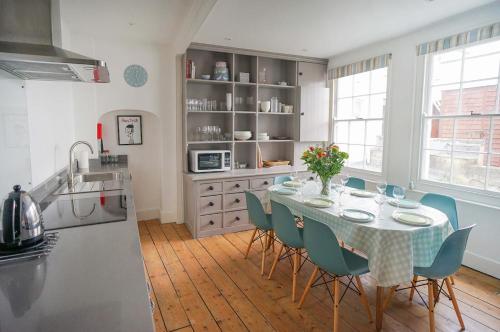 a kitchen with a table and chairs in a kitchen at Woodyear House-4 Bath-Dog Friendly-Cowes-Sleeps 8 in Cowes