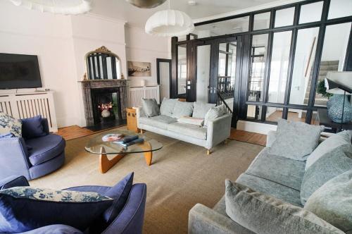 a living room with two couches and a fireplace at Woodyear House-4 Bath-Dog Friendly-Cowes-Sleeps 8 in Cowes