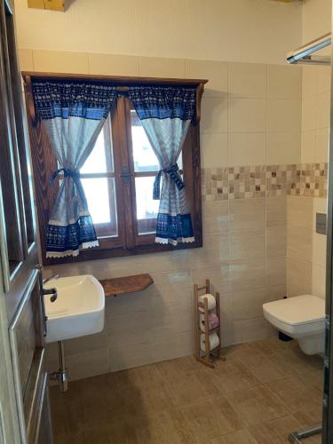 a bathroom with a sink and a window and a toilet at Drevenica u Michala in Terchová