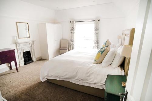 a white bedroom with a bed and a window at Woodyear House-4 Bath-Dog Friendly-Cowes-Sleeps 8 in Cowes