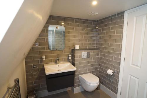 a bathroom with a sink and a toilet at Woodyear House-4 Bath-Dog Friendly-Cowes-Sleeps 8 in Cowes