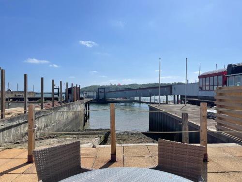 a marina with two chairs and a pier with water at Woodyear House-4 Bath-Dog Friendly-Cowes-Sleeps 8 in Cowes