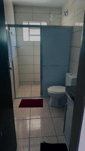 a bathroom with a shower with a toilet and a sink at Pousada Bem estar in Divinópolis