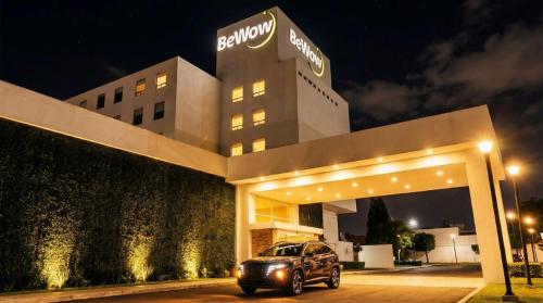 a car parked in front of a building at night at BeWow Hotel Querétaro in Querétaro