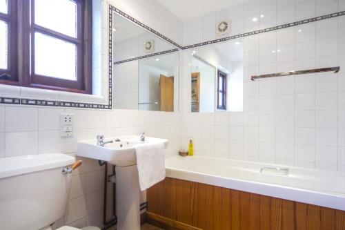a bathroom with a sink and a tub and a toilet at The Long Barn nr Huntsham in Tiverton