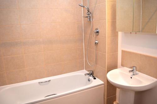 a bathroom with a tub and a sink and a shower at May Cottage nr Huntsham in Tiverton