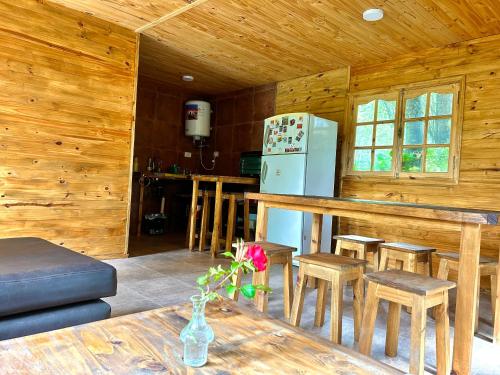 a kitchen with a counter and a refrigerator and a table at Increíble cabaña de montaña in Potrerillos