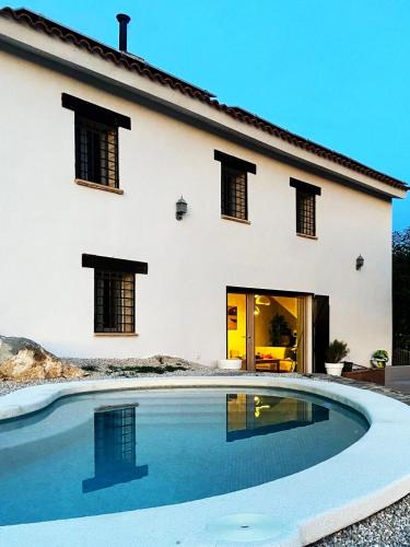 a house with a swimming pool in front of a house at Casa Romeriko piscina privada vistas espectaculares Valle de Ricote Murcia in Ricote